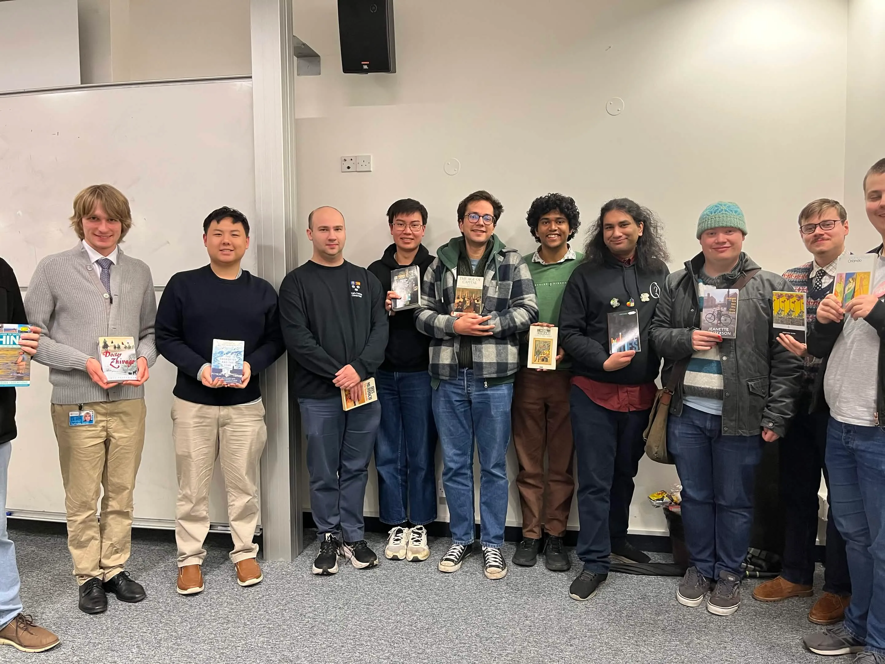 Group of high scorers lined up holding their respective book prizes